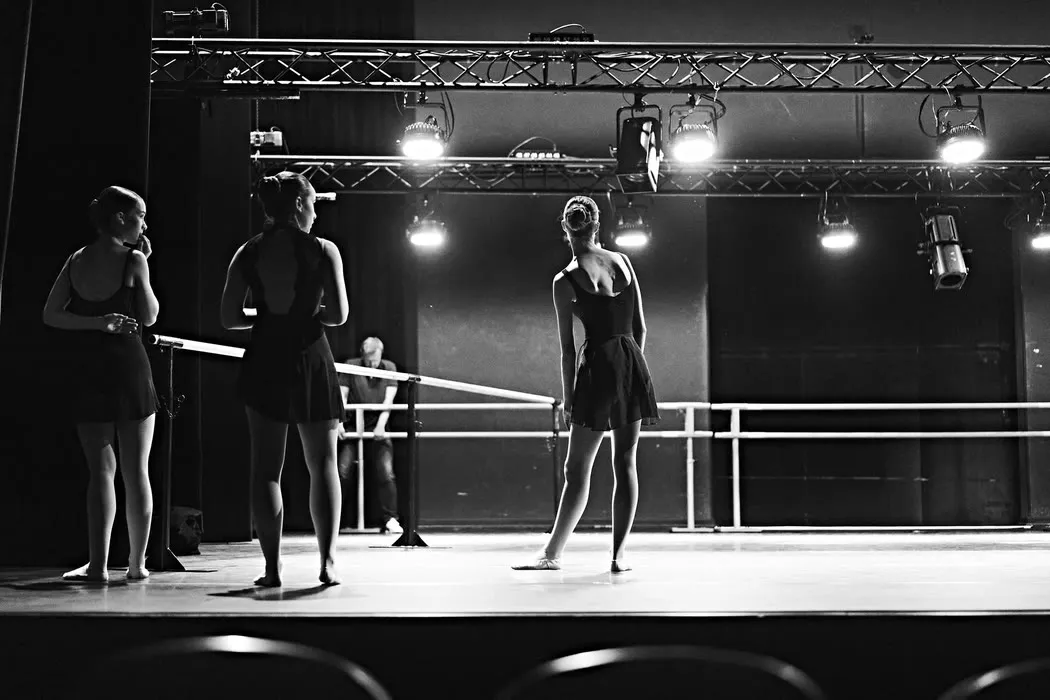 Coulisses — Répétition sur le plateau, sous les projecteurs.